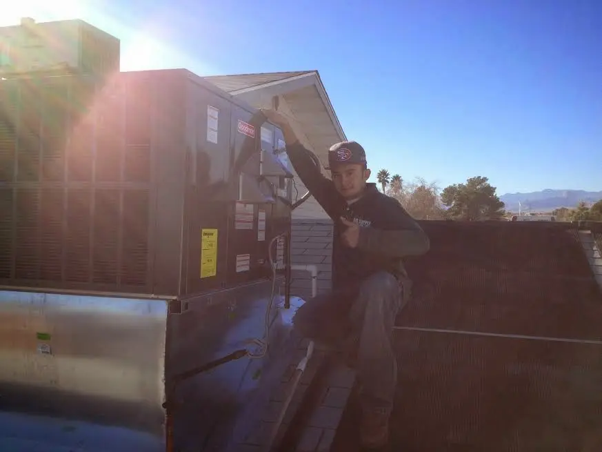 HVAC technician performing AC Tune-Up on a rooftop unit in Avondale